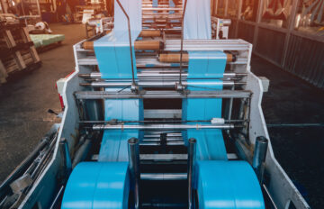 Великий екструдер з рулонами пакетів для сміття в цеху на заводі